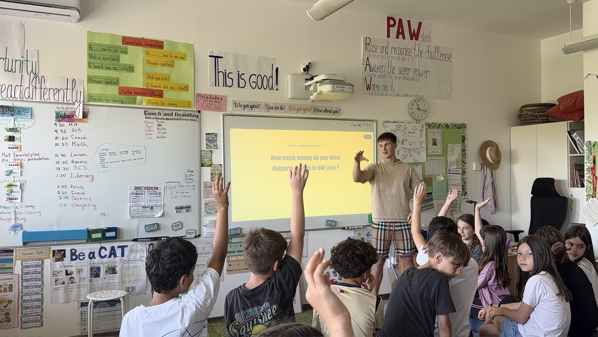 Ученици вдигат ръка пред слайд с въпрос за държавния бюджет